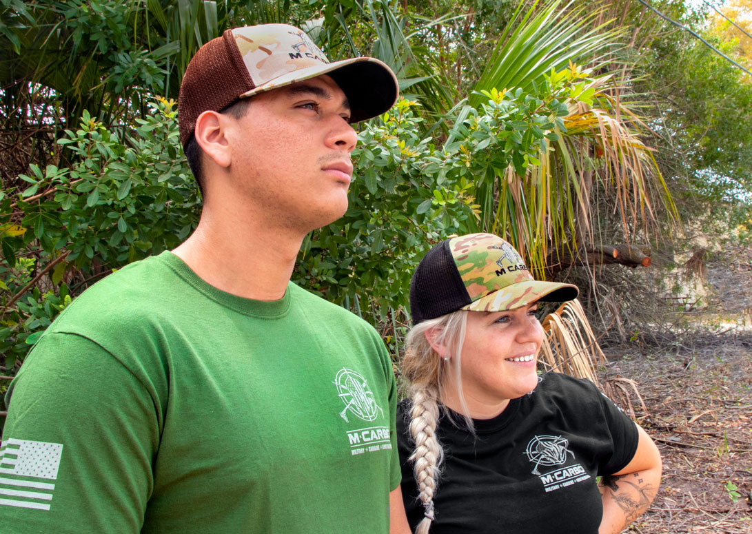 Man and Woman Wearing MCARBO Brotherhood Hats Outdoors