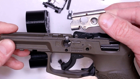 A Gunsmith Removing the Locking Block from a Stripped Down VP9